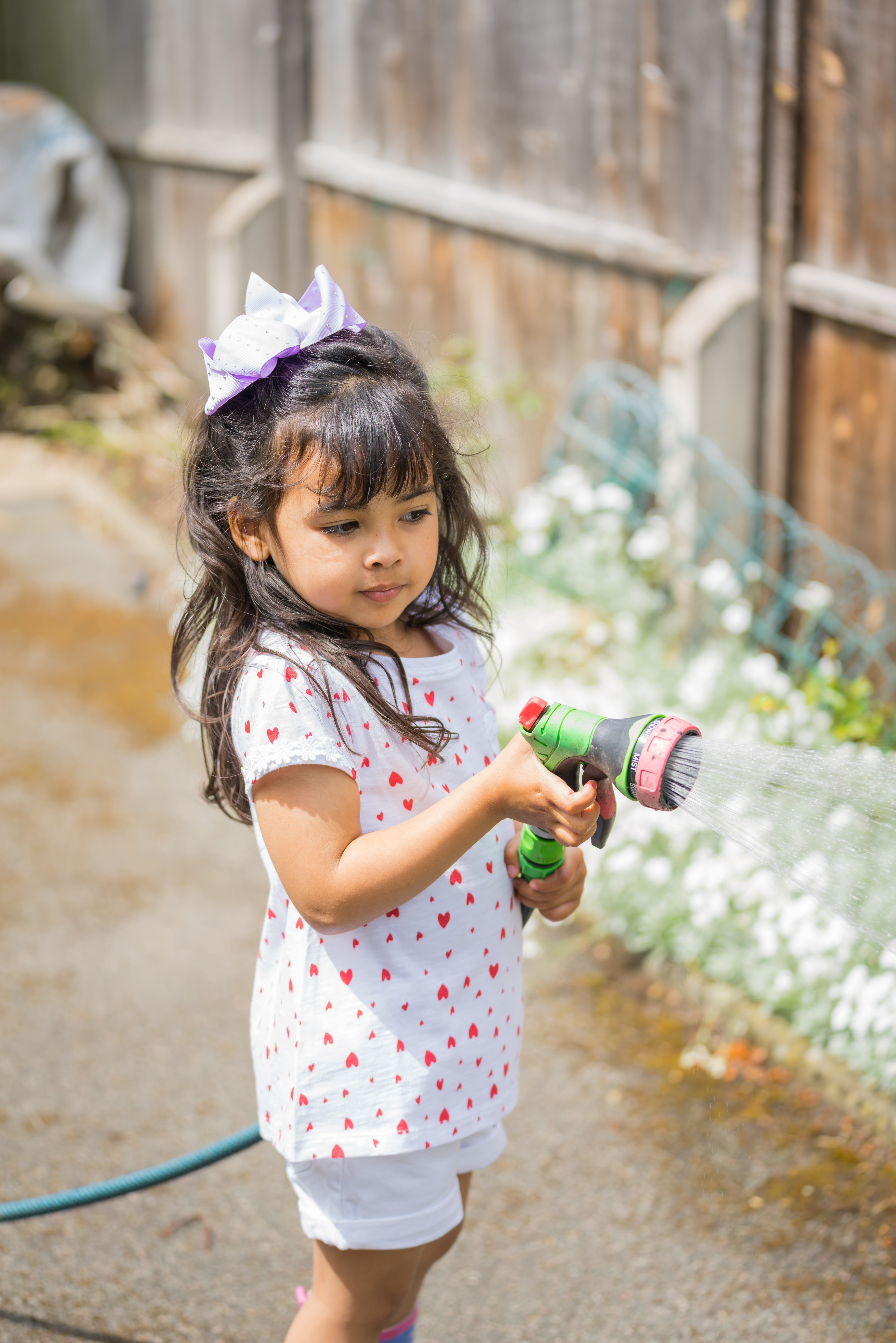 preschooler uses hose in backyard